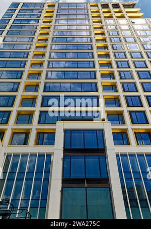 Cielo blu riflesso, finiture in bronzo giallo e calcestruzzo bianco scuro creano motivi impressionanti al 551 West 21st Street, un condominio residenziale. Foto Stock