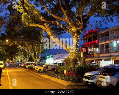 Vista dei negozi, dei bar e dei ristoranti di notte su Macrossan Street, la principale via dello shopping a Port Douglas, Queensland, Australia Foto Stock