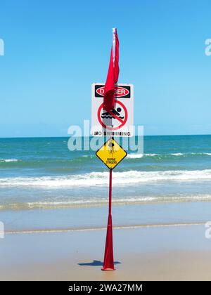 Veduta di un bagnino australiano cartello di divieto di nuoto che avverte del pericolo degli stingers marini su Four Mile Beach a Port Douglas, Queensland, Australia Foto Stock