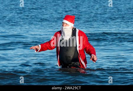 Edimburgo, Scozia, Regno Unito. Lunedì 1 gennaio 2024. Edimburgo, Scozia. Le persone si uniscono al Loony Dook annuale per un tuffo di Capodanno nel mare sulla spiaggia di Portobello a Edimburgo. Crediti: Sandy Robinson/Alamy Live News Foto Stock