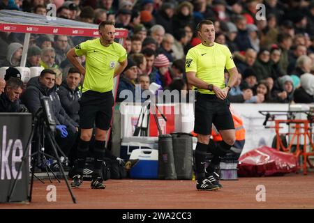 L'arbitro James Bell (a sinistra) è sostituito da Thomas Bramall durante il match per lo Sky Bet Championship al Bet365 Stadium, Stoke-on-Trent. Data immagine: Lunedì 1 gennaio 2024. Foto Stock