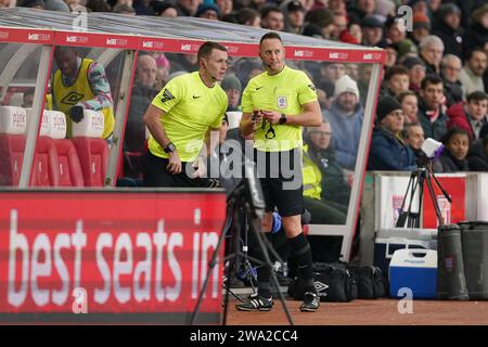 L'arbitro James Bell (a destra) è sostituito da Thomas Bramall durante la partita del campionato Sky Bet al Bet365 Stadium, Stoke-on-Trent. Data immagine: Lunedì 1 gennaio 2024. Foto Stock