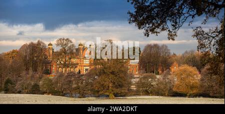 Regno Unito, Inghilterra, Cheshire, Macclesfield, Capesthorne Hall dall'altra parte del lago in inverno, panoramica Foto Stock