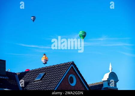 Bunte Heißluftballons über den Dächern der Kieler Altstadt vor blauem Himmel im Sommer Foto Stock