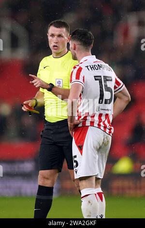 L'arbitro Thomas Bramall manda Jordan Thompson di Stoke City (a destra) durante il match per lo Sky Bet Championship al Bet365 Stadium, Stoke-on-Trent. Data immagine: Lunedì 1 gennaio 2024. Foto Stock