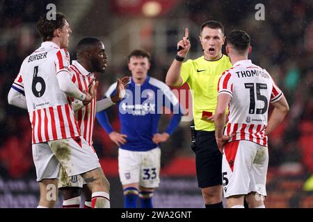 L'arbitro Thomas Bramall manda Jordan Thompson di Stoke City (a destra) durante il match per lo Sky Bet Championship al Bet365 Stadium, Stoke-on-Trent. Data immagine: Lunedì 1 gennaio 2024. Foto Stock