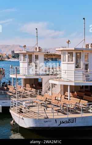 Luxor, Egitto - dicembre 26 2023: I tradizionali traghetti a motore ormeggiati su un molo lungo il fiume Nilo Foto Stock