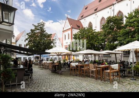 Accoglienti terrazze nella piazza della chiesa parrocchiale dell'assunzione della Vergine Maria nel centro di Landsberg am Lech, Baviera; Germania. Foto Stock