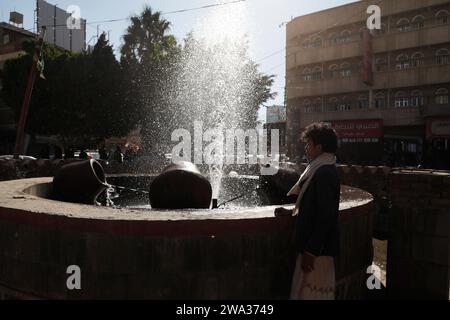 SANAA, Sanaa, Yemen. 1 gennaio 2024. Un giovane si trova accanto a una fontana in Piazza Vecchia Sanaa la prima mattina del nuovo anno 2024. (Immagine di credito: © Osamah Yahya/ZUMA Press Wire) SOLO USO EDITORIALE! Non per USO commerciale! Foto Stock