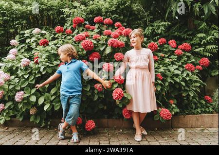 Ritratto all'aperto di due graziosi bambini che giocano insieme nel giardino estivo Foto Stock