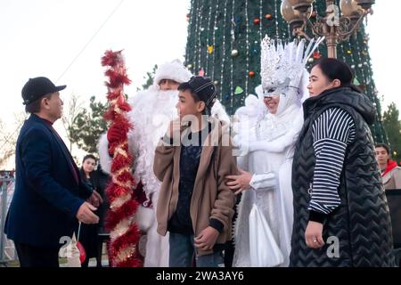 Festa di Capodanno piazza Kuk Saroy Samarcanda Uzbekistan. Padre Frost - Babbo Natale e Snegurochka, signora della neve, costumi che scattano foto Foto Stock