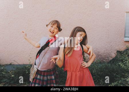 Due ragazze buffe che fanno il grimace, stupide studentesse che giocano insieme dopo la scuola Foto Stock