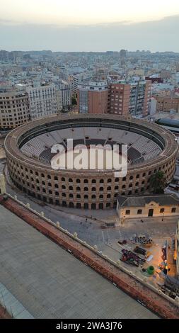 Riprese aeree con drone della Plaça de Bous de València in Spagna, storica arena di corrida neoclassica con archi circolari in mattoni e vista sulla Estació del Nord Foto Stock