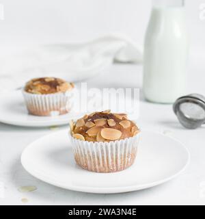 muffin alle mandorle su un piatto bianco, muffin alle mandorle fatte in casa su sfondo bianco Foto Stock