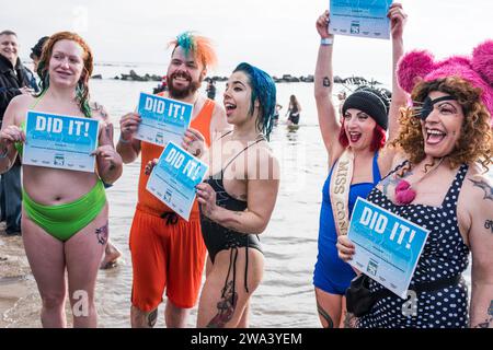 Brooklyn, New York - 1° gennaio 2024: I membri del cast che partecipano al 121° annuale Polar Bear Plunge a Coney Island mostrano il loro certificato di completamento Foto Stock