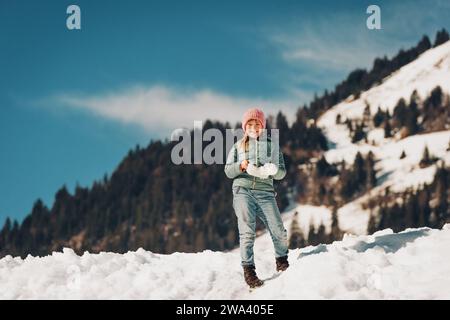 Bambina che sale sulla collina della neve, vacanze invernali con bambini. Immagine scattata in Vallese, Svizzera Foto Stock