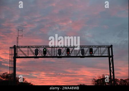 Winfield, Illinois, USA. Un ponte di segnale che mostra diverse autorizzazioni di colore sopra una linea principale a tre binari nel nord-est dell'Illinois. Foto Stock