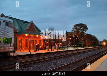 Winfield, Illinois, USA. I pendolari si preparano a salire a bordo di un treno Metra in arrivo alla stazione ferroviaria locale. Foto Stock