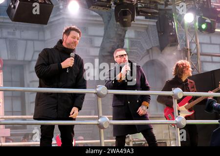 Londra, Regno Unito. 1 gennaio 2024. I membri dei Boyzlife Brian McFadden (L) e Keith Duffy (R) si esibiscono in un float. La folla di Londra si riunisce per assistere alla London New Year's Day Parade (LNYDP) che celebra l'inizio del 2024, con 8.000 partecipanti, composti da bande di marcia, ballerini, cheerleader, esibizioni acrobatiche, rappresentanti delle autorità locali e cantanti, che camminano e si esibiscono lungo il percorso del centro di Londra. Credito: Fotografia dell'undicesima ora/Alamy Live News Foto Stock