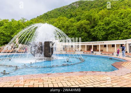 Zheleznovodsk, Russia - 11 maggio 2023: Fontana del geyser Smirnovsky in un giorno d'estate, i visitatori scattano foto Foto Stock