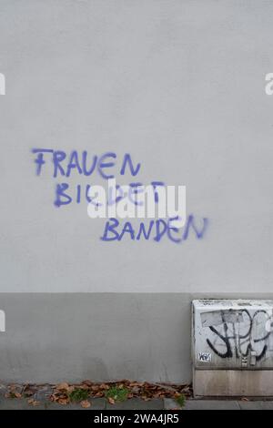 Lo slogan "Women Form Gangs” è scritto su un muro di casa a Colonia-Nippes Foto Stock
