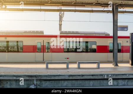 Vista laterale del binario della stazione e del treno pendolare nel parcheggio Foto Stock