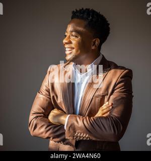 Ritratto di un uomo d'affari felice che sorride e guarda lontano. Foto Stock