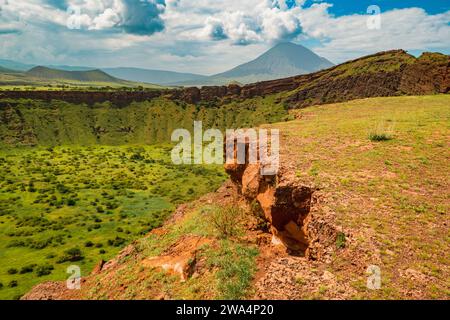 Una vista panoramica di Shimo la Mungu, la fossa del Dio alla fine dell'altopiano di Makonde con il Monte Ol Doinyo Lengai sullo sfondo in Tanzania Foto Stock