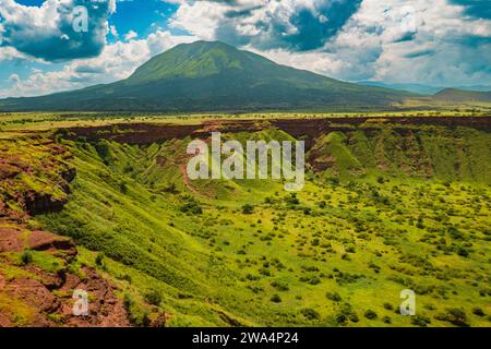 Una vista panoramica di Shimo la Mungu, la fossa del Dio alla fine dell'altopiano di Makonde con il Monte Ol Doinyo Lengai sullo sfondo in Tanzania Foto Stock