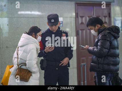 Pechino, provincia cinese di Liaoning. 2 gennaio 2024. Un ufficiale di polizia assiste i passeggeri alla stazione ferroviaria nord di Shenyang a Shenyang, provincia di Liaoning, nel nord-est della Cina, 2 gennaio 2024. Crediti: Long lei/Xinhua/Alamy Live News Foto Stock