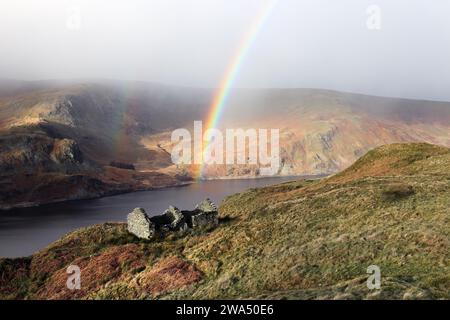 Arcobaleno su un edificio in rovina vicino alla Old Corpse Road con vista su Haweswater, Lake District, Cumbria, Regno Unito, Foto Stock