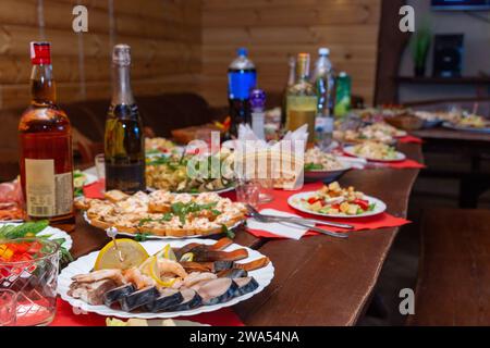 Antipasti assortiti serviti su un tavolo di legno, primo piano. Un tavolo festivo per festeggiare un compleanno o un'altra vacanza. Foto Stock