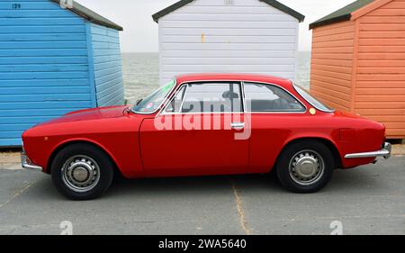 Auto classica Alfa Romeo rossa parcheggiata di fronte al Beach Hut sul lungomare Foto Stock