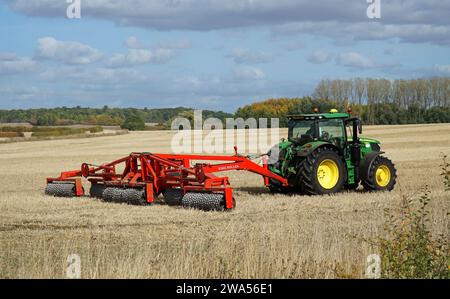 Trattore sul campo con impacchettamento del terreno King Roller nelle giornate di sole Foto Stock