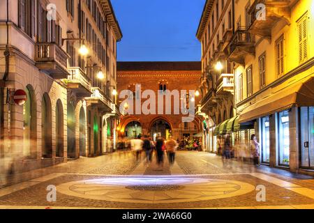 Scena di strada (via Vittorio Emanuele II) che conduce all'antico Arengario (municipio) di Monza, Italia di notte. Foto Stock