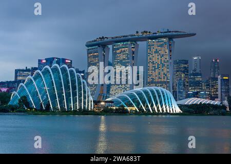 L'iconica Marina Bay Sands e altri edifici sul lungomare nel centro di Singapore durante un tramonto tempestoso Foto Stock