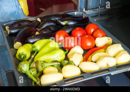 verdure diverse melanzane pomodori peperoni patate su una teglia da forno Foto Stock