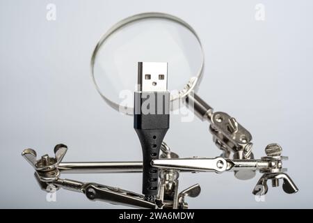 Lente d'ingrandimento a mani libere con clip a coccodrillo che fissano il cavo usb della porta del connettore del computer periferico Foto Stock