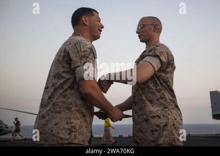 Forze militari STATUNITENSI. 140501HZ646-042 U.S. 5TH FLEET AREA OF RESPONSIBILITY (1 maggio 2014) il sergente del corpo dei Marines degli Stati Uniti Shawn Ponterio, 22nd Marine Expeditionary Unit (MEU) specialista dei servizi legali e nativo di Stafford, Virginia, riceve il mandato di promozione dal maggiore Eric Montalvo, avvocato giudice dello staff dell'MEU, dopo essere stato bloccato al suo attuale rango durante una cerimonia di promozione a bordo della USS Bataan (LHD 5). Il 22nd MEU è schierato con il Bataan Amphibious Ready Group come riserva teatrale e forza di risposta alle crisi in tutto lo U.S. Central Command e l'area di responsabilità della 5th Fleet. (U.S. Marin Foto Stock