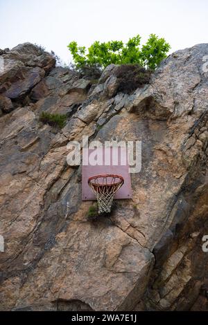 Cestino a palla appeso da una parete di roccia Foto Stock