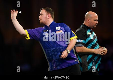 Luke Littler in azione contro Rob Cross (a destra) nel giorno 15 del Paddy Power World Darts Championship ad Alexandra Palace, Londra. Data immagine: Martedì 2 gennaio 2024. Foto Stock