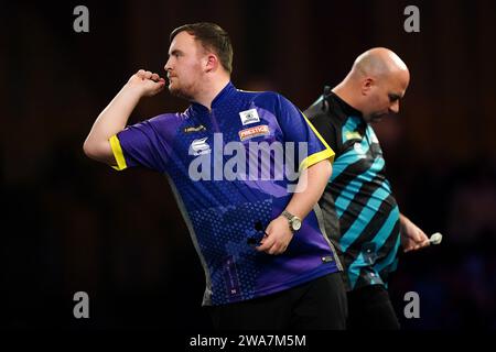 Luke Littler in azione contro Rob Cross (a destra) nel giorno 15 del Paddy Power World Darts Championship ad Alexandra Palace, Londra. Data immagine: Martedì 2 gennaio 2024. Foto Stock