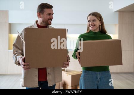 Coppia di sposi che si spostano in un nuovo appartamento con scatole di cartone e cose insieme. Foto Stock