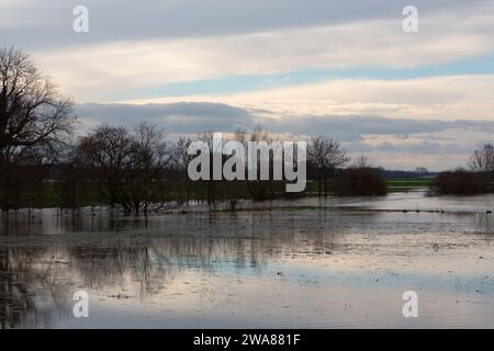 Il fiume Lippe ha fatto irruzione sulle sue sponde. L'acqua alta ha inondato un campo. Le nuvole si riflettono nell'acqua. Foto Stock