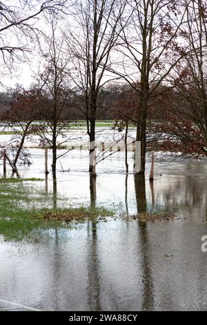 Il fiume Lippe ha fatto irruzione sulle sue sponde. L'acqua alta ha inondato un campo. Le nuvole e gli alberi si riflettono nell'acqua. Foto Stock