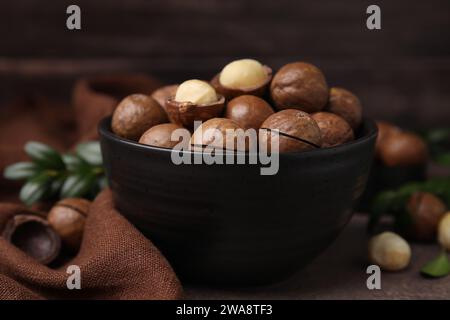 Gustosi noci di Macadamia in ciotola sul tavolo, primo piano Foto Stock