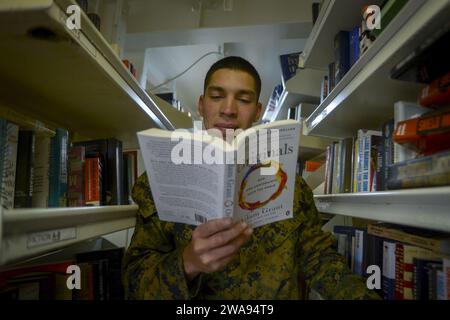 Forze militari STATUNITENSI. 180430AT135-023 OCEANO PACIFICO (30 aprile 2018) corpo dei Marines Lance CP Bryan pena, assegnato alla 1st Light Armored Reconnaissance (LAR), legge un libro nella biblioteca a bordo della nave d'assalto anfibio classe Wasp USS Essex (LHD 2) durante l'Essex Amphibious Ready Group (ARG) e la 13th Marine Expeditionary Unit (MEU) Expeditionary Unit (ARGMEUEX). ARGMEUEX migliora l'integrazione congiunta, la letalità e le capacità collettive del team Marina-Marina attraverso la pianificazione congiunta e l'esecuzione di scenari di addestramento impegnativi e realistici. (Foto della Marina degli Stati Uniti di Mass Communication Specialist 3rd Class Matt Foto Stock