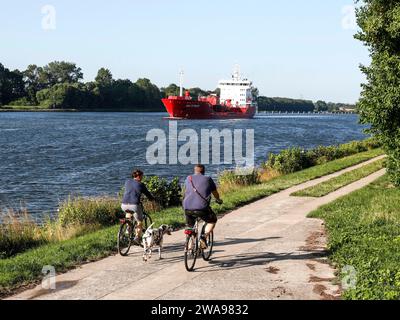 La petroliera chimica Golfstraum naviga sul canale di Kiel, ciclista con cane sulla pista ciclabile lungo il canale, Rendsburg, 16 luglio 2023 Foto Stock