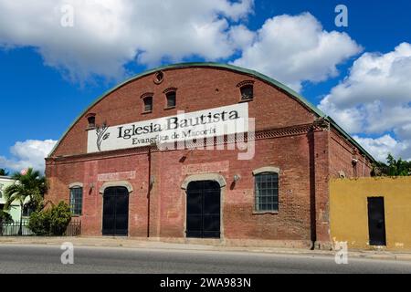 Chiesa in mattoni rossi sotto un cielo blu con poche nuvole, Chiesa Battista protestante, Iglesia Bautista Evangélica de Macorís, San Pedro de Macoris, Dominica Foto Stock