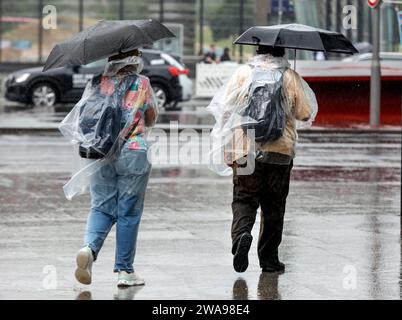 Turisti con cappe e ombrelli durante le piogge pesanti, Berlino, 23 06 2023 Foto Stock